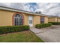 Charming single-story home featuring manicured front bushes and a welcoming walkway to the front door at 635 Lake Marion Golf Resort, Kissimmee, FL 34759