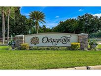 Landscaped Orange Tree community sign with flowers, shrubbery, palm trees, and green lawns in a tranquil neighborhood at 6641 Doubletrace Ln, Orlando, FL 32819