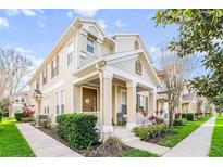 Charming townhome featuring a welcoming front porch, manicured landscaping, and classic architectural details at 7128 Red Lantern Dr # 0, Harmony, FL 34773
