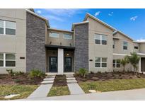 Modern townhome exterior with stone accents, manicured landscaping, and inviting entryways at 1048 Leader St, Davenport, FL 33896