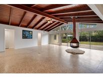 Spacious living room featuring a wood ceiling, modern fireplace, and sliding glass doors to the outdoors at 1590 Twelve Oaks Cir, Kissimmee, FL 34744