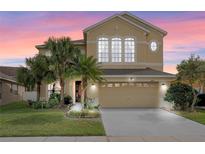 Charming two-story home featuring a two-car garage, lush landscaping, and a beautifully maintained lawn at 2020 Windcrest Lake Cir, Orlando, FL 32824