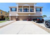 Exterior shot showing three-story townhome with garages, driveway, and second story balcony at 2120 Betsy Ross Ln, St Cloud, FL 34769