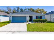 Charming single-story home featuring a well-manicured lawn, attached garage, and neutral color scheme at 2461 Bulrush Dr, St Cloud, FL 34769