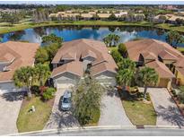 Aerial view of a home on a lot with a water view and paver driveway at 3384 Fallbrook Dr, Poinciana, FL 34759