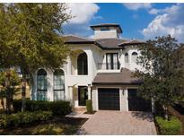Stunning two-story home with a three-car garage, brick driveway, and beautiful landscaping at 361 Muirfield Loop, Reunion, FL 34747