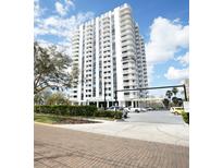 Exterior of a condominium building with white balconies against a blue sky with puffy white clouds at 400 E Colonial Dr # 1504, Orlando, FL 32803