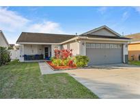 Charming single-story home features a well-manicured lawn, a covered porch with seating, and an attached two-car garage at 4614 Osceola Point Trl Trl, Kissimmee, FL 34746