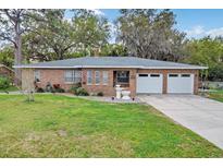 Charming brick home featuring a well-maintained lawn, double garage, and inviting facade at 4884 Meadow Dr, St Cloud, FL 34772
