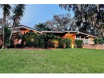 Charming single-story home with lush landscaping and mature palm trees under a twilight sky at 5019 Saint Germain Ave, Orlando, FL 32812