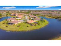 Beautiful aerial view of homes surrounding a lake with lush green landscaping, and tile roofs at 551 San Raphael St, Kissimmee, FL 34759