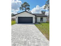 Charming single-story home featuring a gray driveway, two-car garage, and a well-manicured lawn at 6 Bahia Course Ln, Ocala, FL 34472