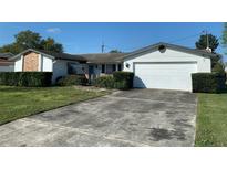 Charming single-story home with a well-maintained lawn, a two-car garage and lovely curb appeal at 706 Francis St, Kissimmee, FL 34741