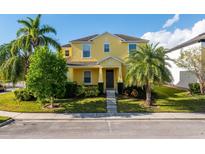 Bright yellow two-story home featuring a well-manicured lawn and mature palm trees at 1000 Seburn Rd, Apopka, FL 32703