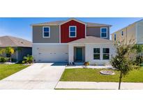 Charming two-story home featuring a two-car garage and a well-manicured lawn at 1396 Axel Cir, Winter Haven, FL 33880