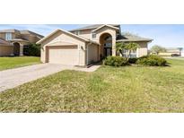 Charming home featuring a well-manicured lawn and attached two-car garage at 4301 Presidio Way, Kissimmee, FL 34746