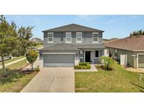 Charming two-story home with a well-maintained lawn, lush landscaping, and a spacious two car garage at 5640 Silver Thistle Ln, St Cloud, FL 34772