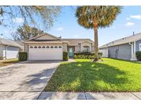Charming single-story home featuring a well-maintained lawn and a light blue front door at 7706 Water Oak Ct, Kissimmee, FL 34747