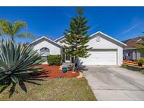 Charming one-story home with a well-manicured lawn, mature landscaping, and a two-car garage at 919 Lake Charles Dr, Davenport, FL 33837