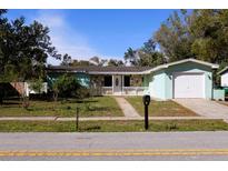 Quaint single-story home featuring a mix of stone and siding, plus an attached garage and well-maintained front yard at 1102 Whitewood Dr, Deltona, FL 32725