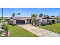 Charming single-story home features a well-manicured lawn, mature landscaping, and a two-car garage at 2512 Virginia Dr, Kissimmee, FL 34741
