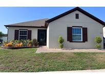 Charming one-story home featuring neutral stucco, brick-lined flower bed, and a tidy, well-maintained lawn at 2885 Running Brook Cir, Kissimmee, FL 34744
