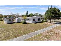 An exterior view of a white house with a well-maintained yard and lush greenery at 425 S 12Th St, Lake Wales, FL 33853