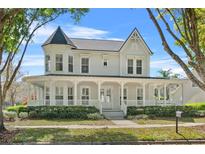 Charming two-story home with a inviting wraparound porch, turret, and manicured lawn at 1251 Aquila Loop, Celebration, FL 34747