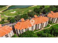 Beautiful aerial view of the condo complex overlooking a lush green golf course and serene lake at 1370 Tuscana Ln # 5406, Davenport, FL 33896