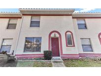 Charming townhome with a red door, cream stucco and red trim plus nicely kept front lawn area at 1631 Little Falls Cir # 92, Orlando, FL 32807