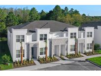 Modern townhome featuring stone accents, a neutral color scheme, and landscaped surroundings at 17220 Blessing Dr, Clermont, FL 34714