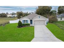 Inviting single-story home featuring a manicured lawn, driveway, and attached two-car garage at 1851 Maureen Dr, Deltona, FL 32738