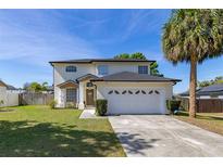 Charming two-story home with a well-maintained lawn, a two car garage and a beautiful palm tree at 2313 Duncan Trl, Clermont, FL 34714