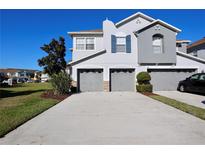 Attractive townhome featuring a two-car garage, manicured lawn and ample parking space in front at 2515 Hassonite St, Kissimmee, FL 34744