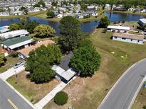 Aerial view of a home near a lake with mature trees and community, offering a serene setting at 2601 Salina Way, Kissimmee, FL 34758