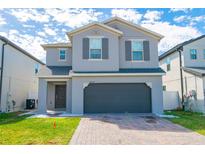 Charming two-story home with a paved driveway, two car garage and manicured lawn at 2804 Alpine Meadow Ln, Kissimmee, FL 34744