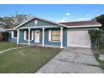 Charming single-story home with a blue exterior, white pillars, and a well-maintained front yard at 4861 Haines Circle, Orlando, FL 32822