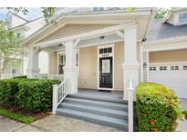Charming front porch with white columns and a well-manicured garden at 1027 Banks Rose St, Celebration, FL 34747