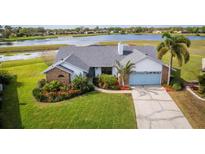 Beautiful single-story home featuring mature landscaping, a two-car garage, and tranquil lake views at 2718 Nakina Ct, Orlando, FL 32837