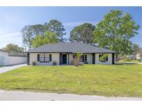 Charming single-story home featuring neutral paint, black accents, and a well-maintained lawn and inviting curb appeal at 2931 Chilton St, Deltona, FL 32738