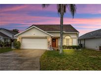 Charming single-Gathering home featuring a well-manicured lawn, a two-car garage, and lovely landscaping at 723 Allison Ave, Davenport, FL 33897