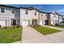 Charming townhomes with colorful facades, well-maintained lawns, and driveways leading to attached garages at 728 Madison Dr, Davenport, FL 33837