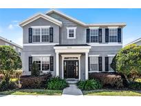 Charming two-story home featuring a well-manicured front yard and black shutters at 7412 Soiree Way, Reunion, FL 34747