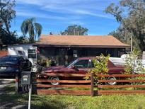 Cozy single story home with light siding, a screened in porch, and mature landscaping at 731 Trenton Rd, Lakeland, FL 33815