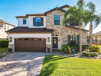 Charming two-story home featuring stone accents, a well-manicured lawn, and a two car garage at 1061 Fountain Coin Loop Loop, Orlando, FL 32828