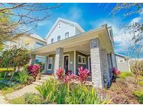 Charming two-story home with a welcoming front porch and colorful landscaping at 13041 Gabor Ave, Orlando, FL 32827
