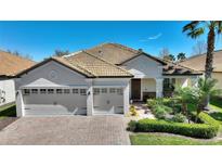Charming home featuring a three-car garage, terracotta roof, and neatly manicured landscaping at 1313 Gleneagles Ln, Davenport, FL 33896