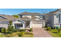 Charming two-story home with well-manicured landscaping and a brick driveway at 14321 Wabasso Loop, Winter Garden, FL 34787