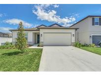 Charming single-story home with a well-manicured lawn, two-car garage, and welcoming facade at 2039 Derwent Dr, Davenport, FL 33896