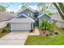 Charming two-story home featuring a well-maintained lawn, mature landscaping, and a two-car garage at 2105 Mallory Cir, Haines City, FL 33844